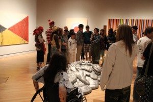 Groups of teens gathered around an actor playing "Rosie the Riveter" as part of the murder mystery event. 