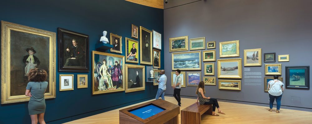 Guests viewing artwork in a salon hang.