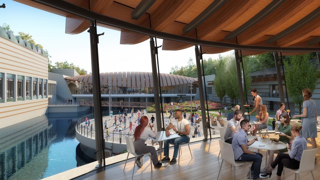 Modern dining area with large windows overlooking an outdoor courtyard with people socializing.