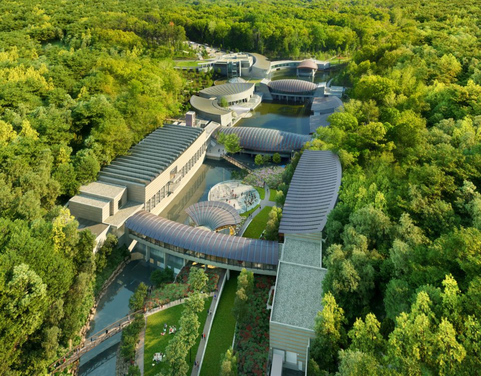 Modern architectural complex with curved roofs in a lush forested area, connected by pathways.