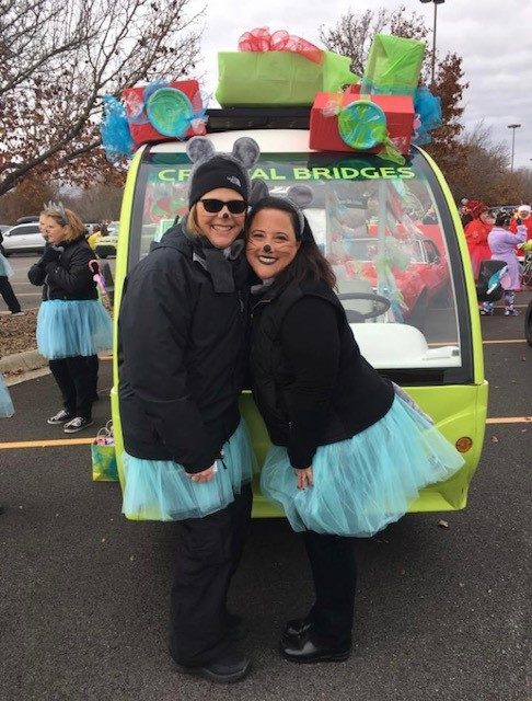 two staff members pose at the Bentonville Christmas Parade.
