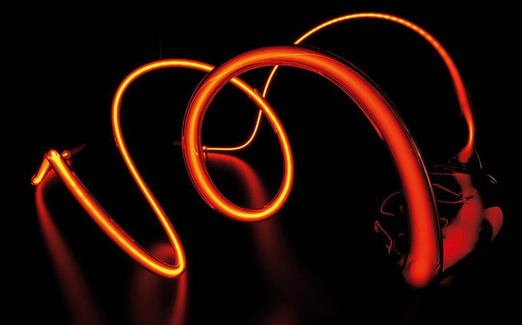 Orange to yellow neon tube of light in the shape of swirls