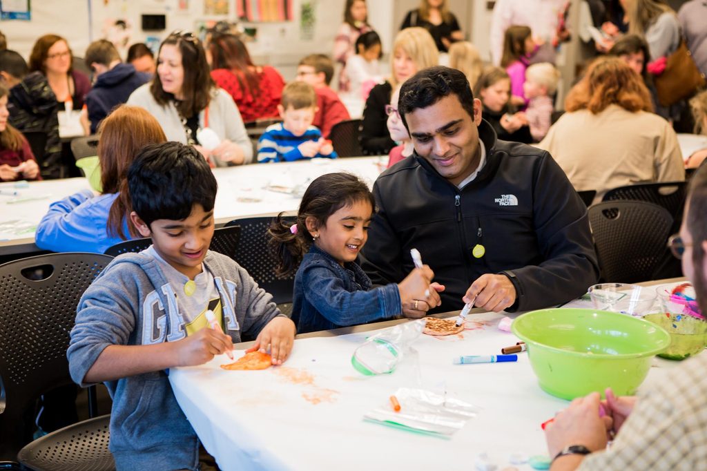 Two kids and an adult making art at a family event