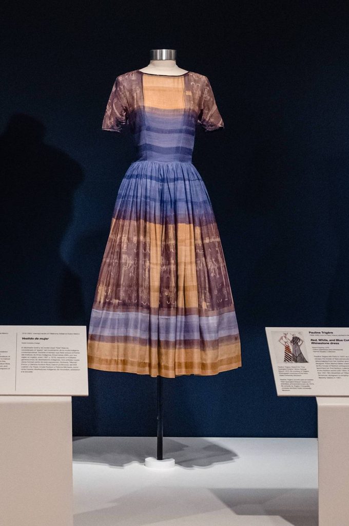 a purple and tan silk woman's dress on a mannequin in a gallery space