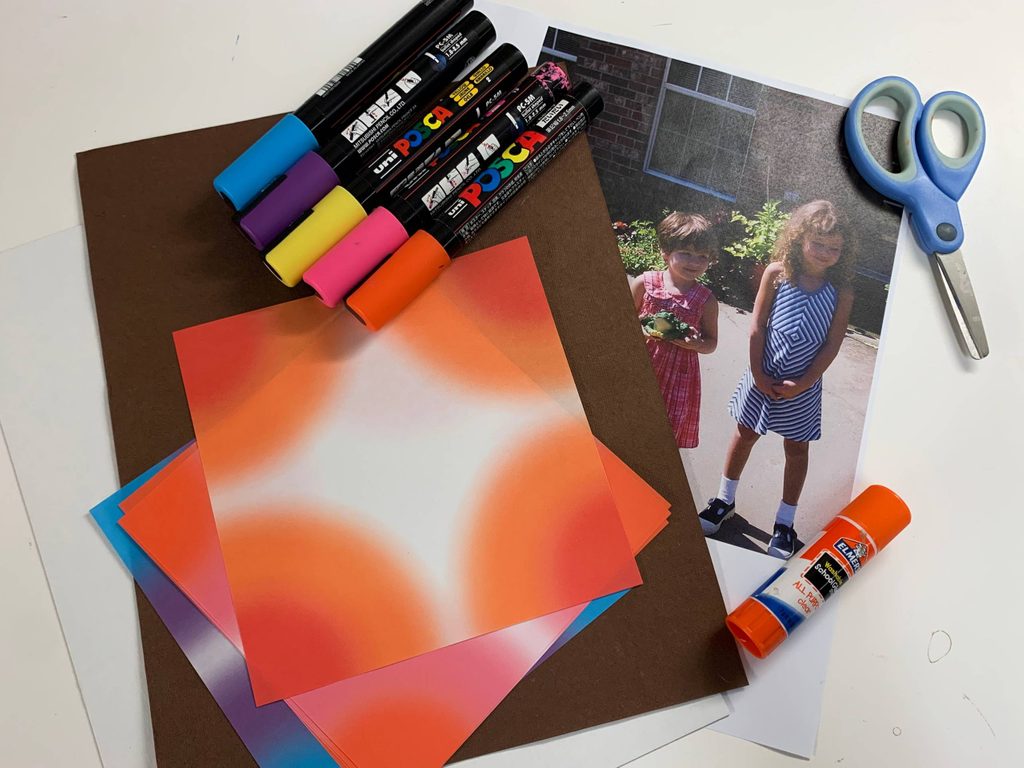 materials for an artmaking activity including brown paper, orange paper, picture of two young girls, scissors, markers, and glue stick