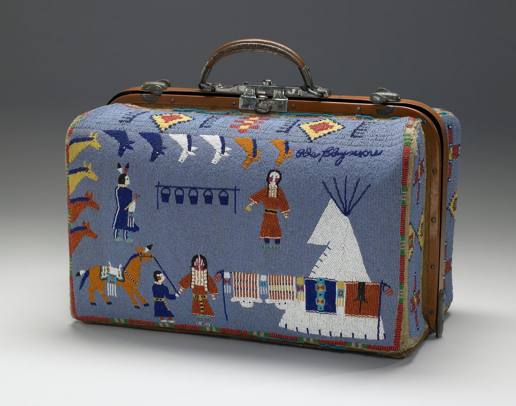 Suitcase with beadwork of Native American figures, horses, and a teepee on a blue background.