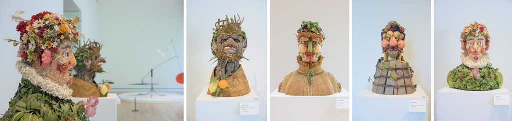Sculptural busts created from fruits, vegetables, and flowers in a gallery display.