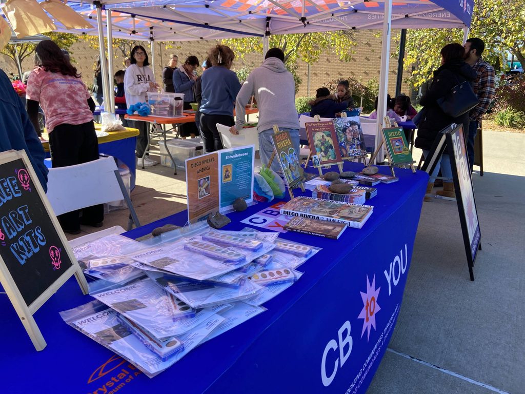 a Crystal Bridges booth featuring art kits and books about Diego Rivera