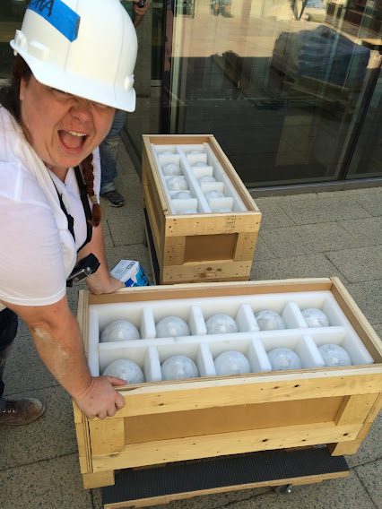 staff member unpacks ceramic balls for maman installation
