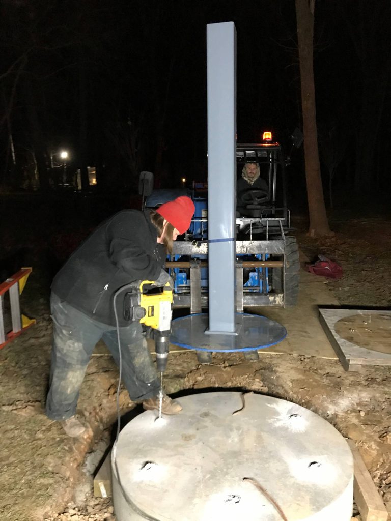 staff member installs an outdoor sculpture.
