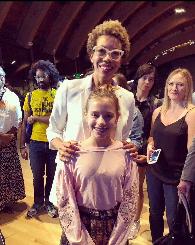 a young female visitor poses with artist amy sherald in the great hall