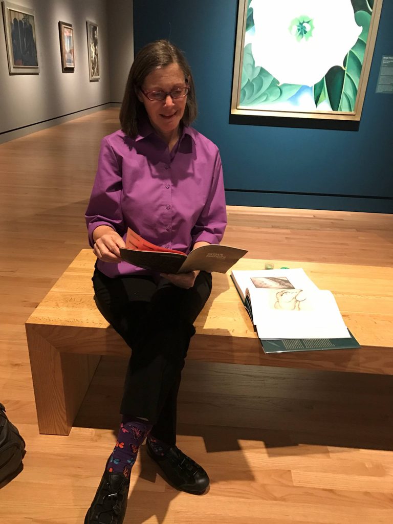 a volunteer reading a book in the gallery