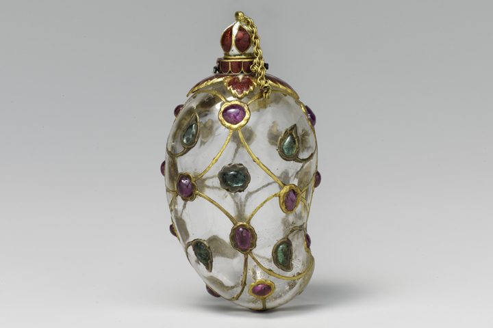Ornate transparent flask with colorful gemstones, gold filigree, decorative chain, and cap.