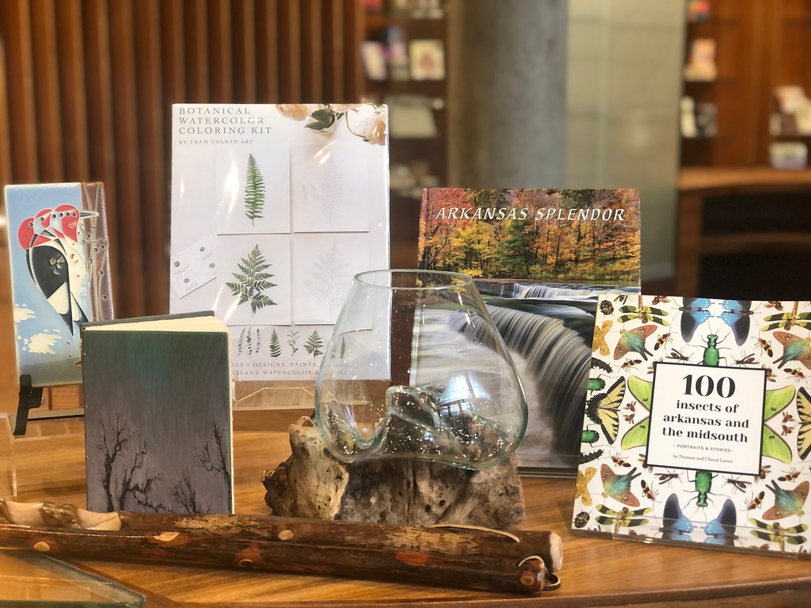 Books displayed on wood with titles and decorative glass piece.