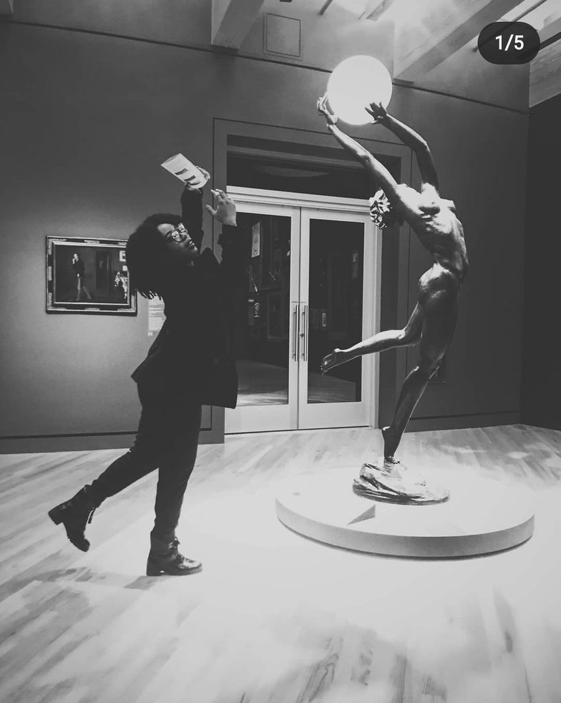 a female visitor stands in the pose of the bubble sculpture