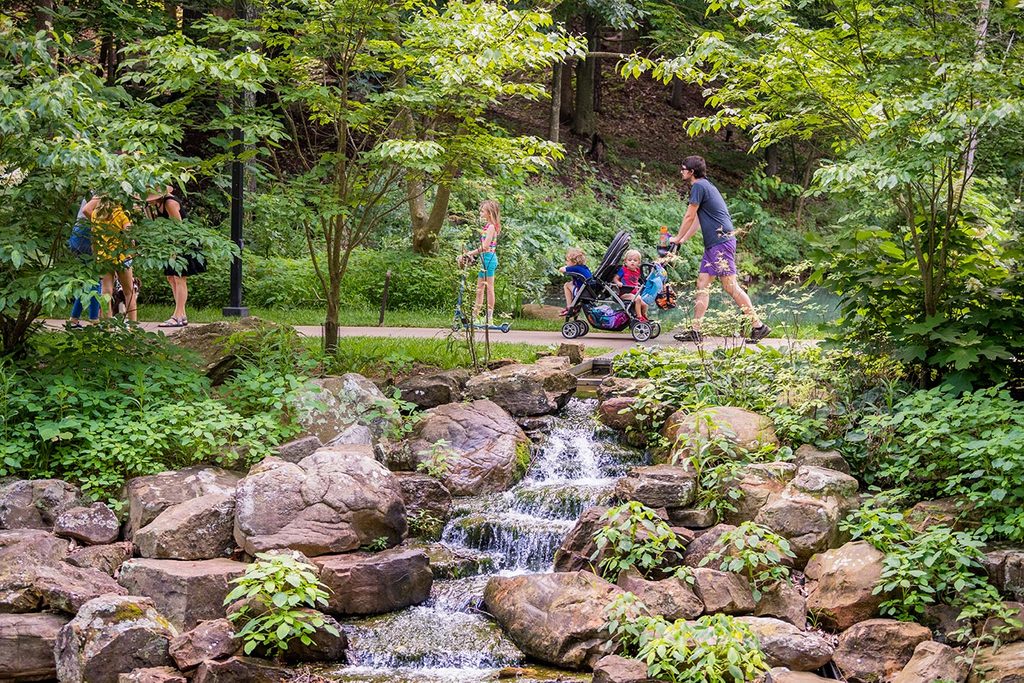 People walking on trails with waterfall