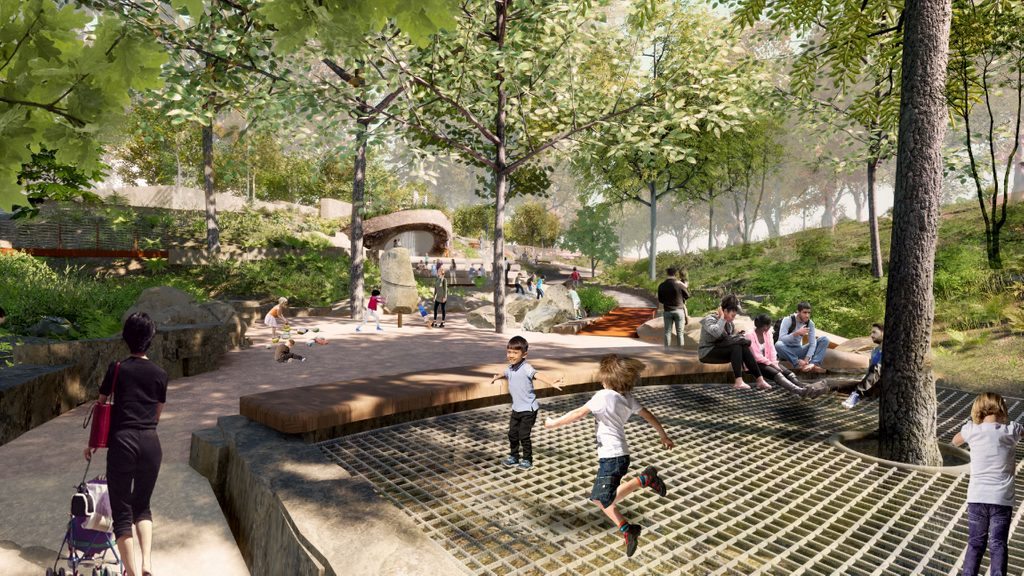 Park with children playing on a large ground-level grid trampoline and adults nearby on benches.