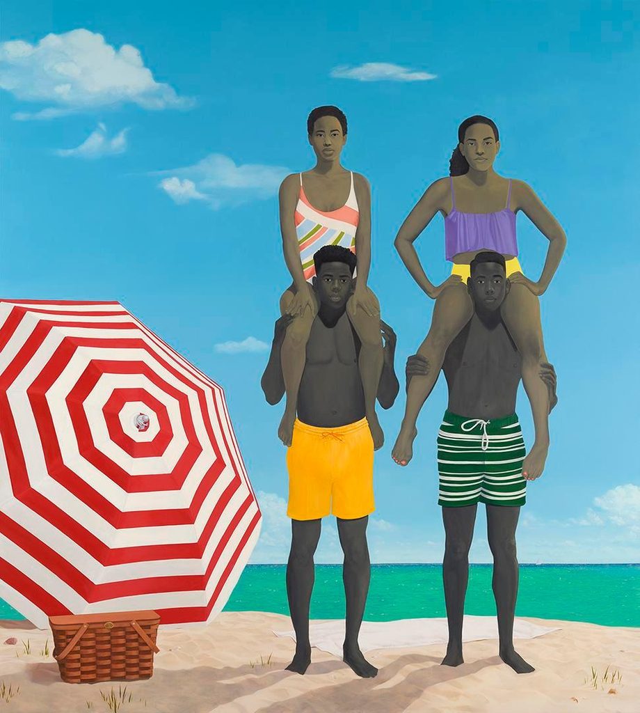 Men carrying women on shoulders at beach, with striped umbrella and picnic basket nearby.