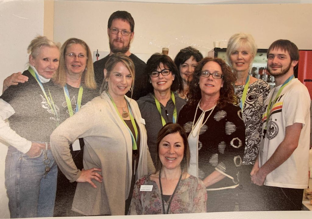 picture of guest services associate sally clifton with nine other people who were part of the first Museum Store team