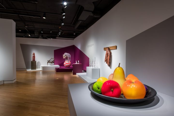 Contemporary art gallery with colorful fruit sculptures and various installations.