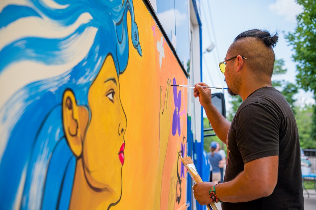 Community event in fayetteville as an artist paints on a bus