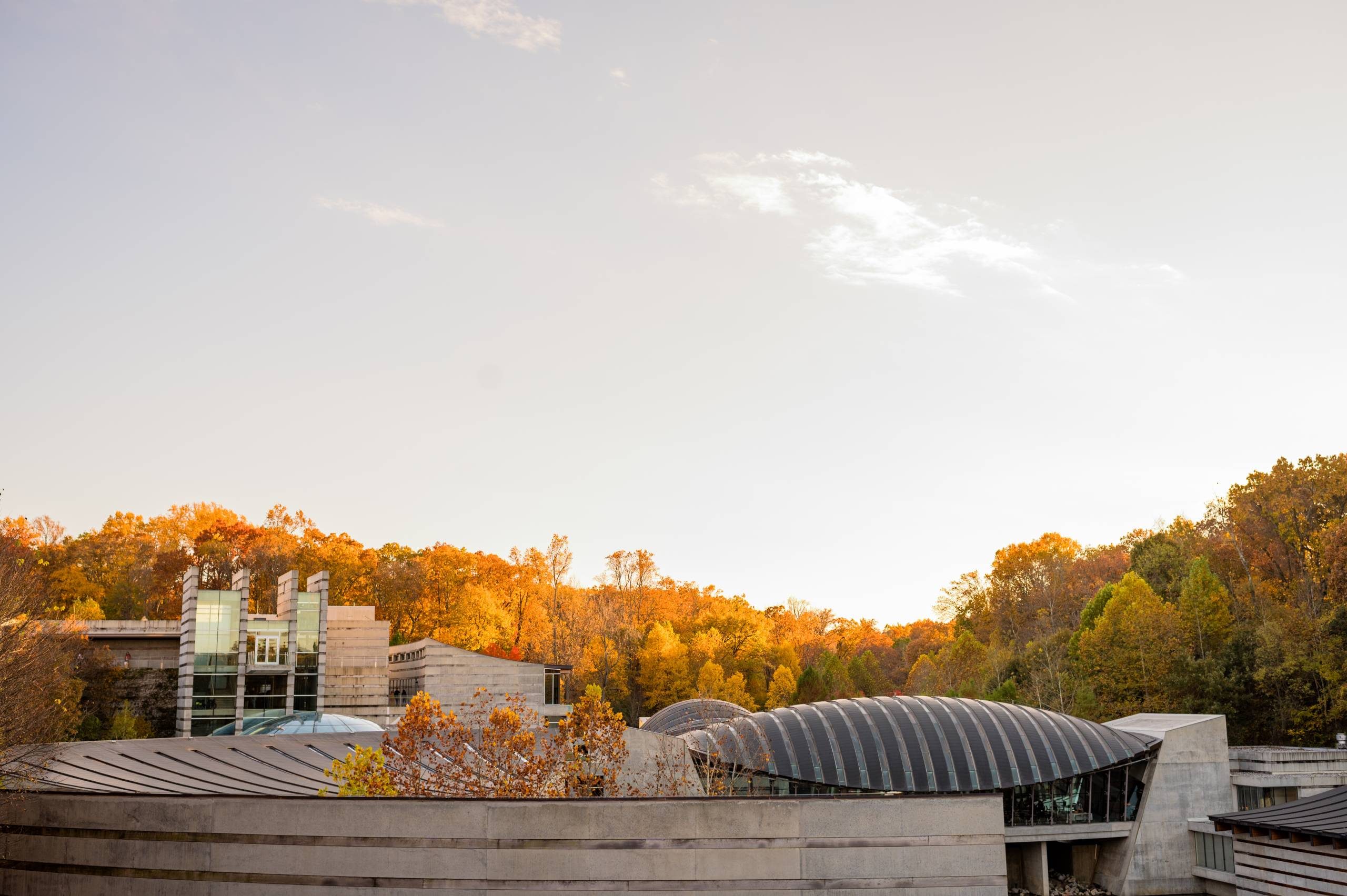 an outdoor view of crystal bridges with a line of autumn trees in the background