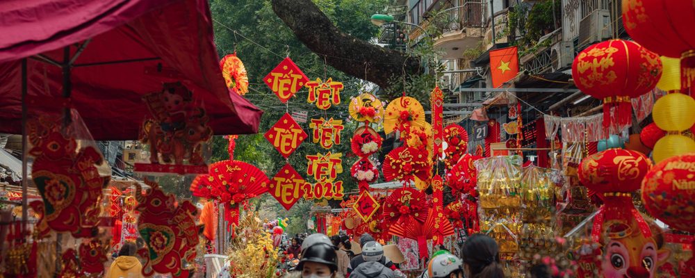 a vietnam street decorated with red and yellow streamers, banners, and lanterns during Tet