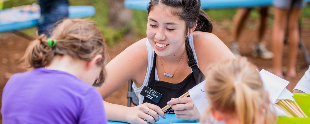 Volunteer helping children make art