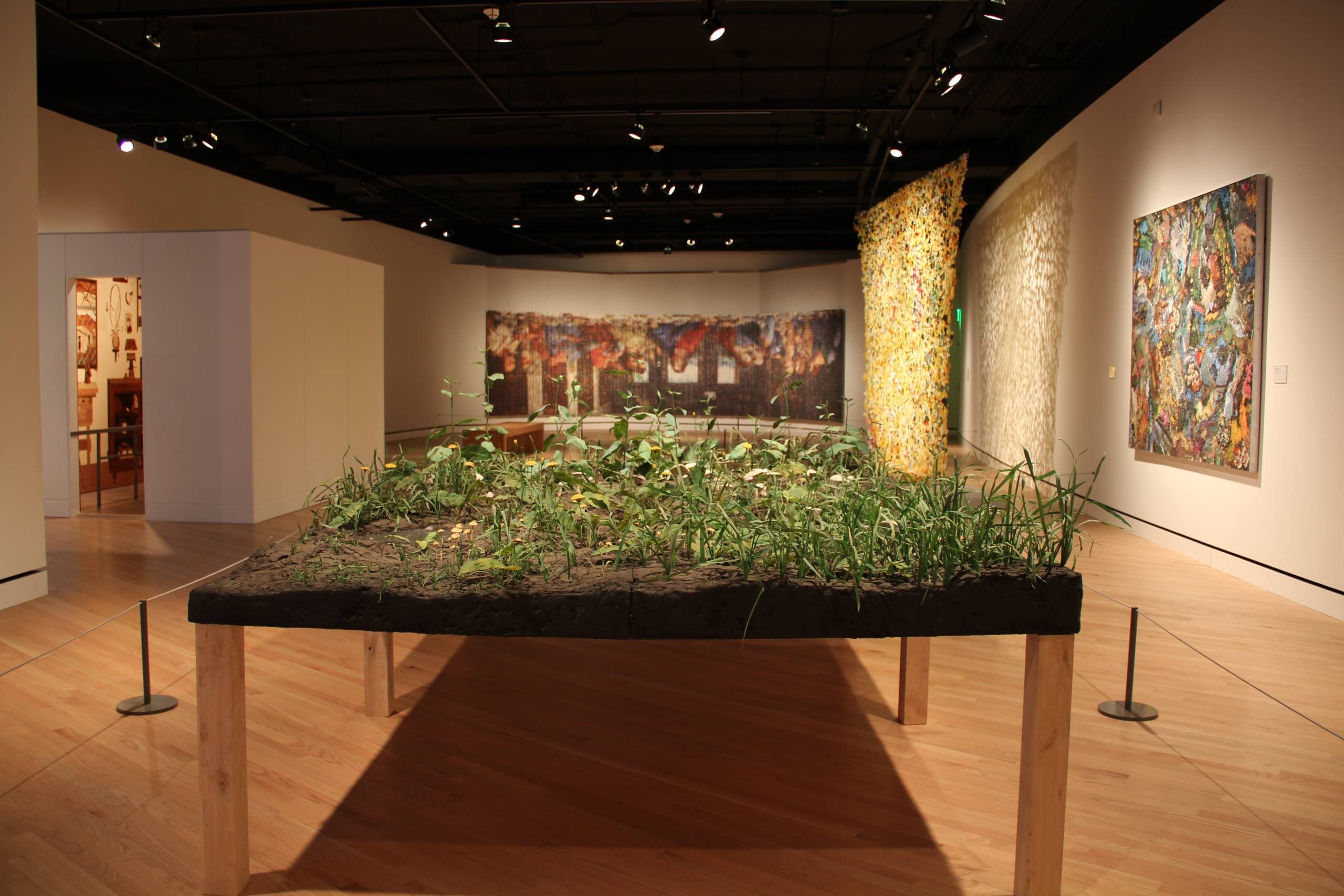 picture of a gallery from the exhibition wonder world, including a sculpture of a table with grass and dirt on top of it